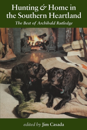 Photograph of two black dogs laying on a blanket in front of a fireplace. White title and subtitle above and editor name below.